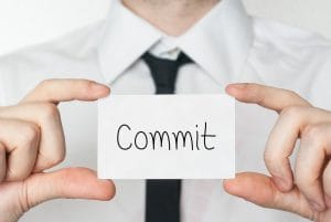 Commit. Businessman in white shirt with a black tie showing or holding business card